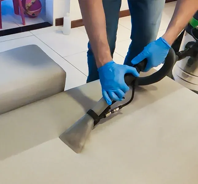 Armchair seat being cleaned with an upholstery extraction tool