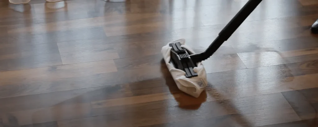 Wooden floor being cleaned with a flat mop