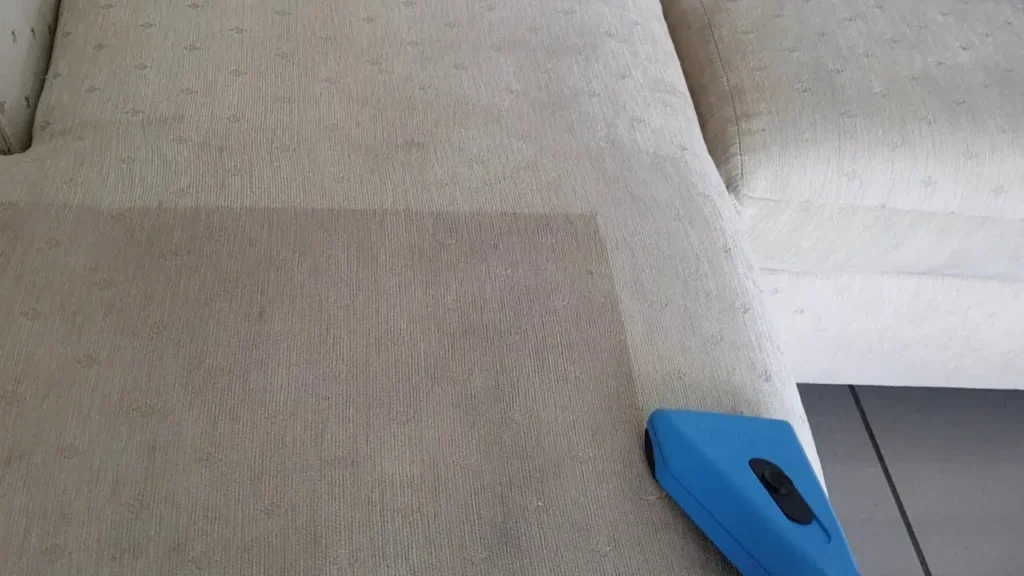 Sofa seat half cleaned, showing the difference a deep clean makes